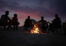 Illustrer l’Imaginaire : Créez une Image de Monstres Amicaux et Flous autour d’un Feu de Camp Créez une image de monstres amicaux et flous rassemblés autour d’un feu de camp